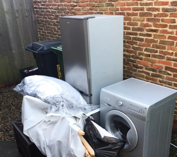 a bulky waste collection including black bin bags refuse sacks fridge and washing machine white appliances