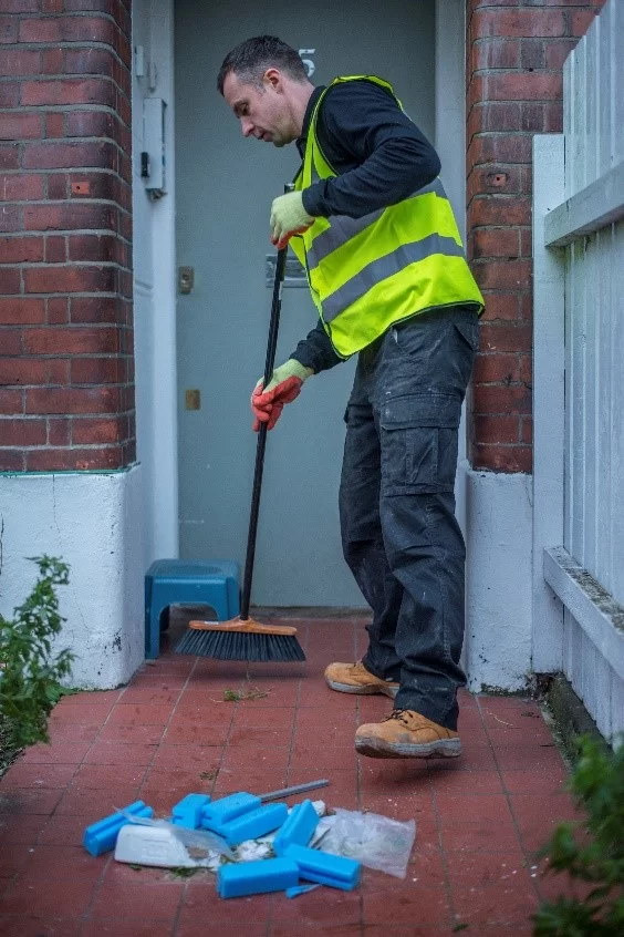 anyjunk man in high vis sweeping up waste